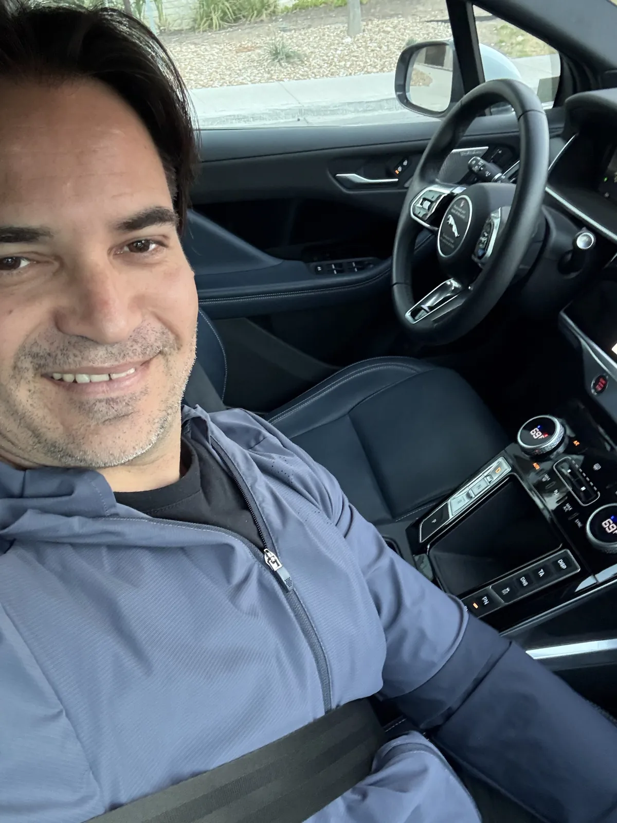 Selfie de Ivaldo no banco de trás de um Waymo, com o banco do motorista vazio e o volante sem ninguém
