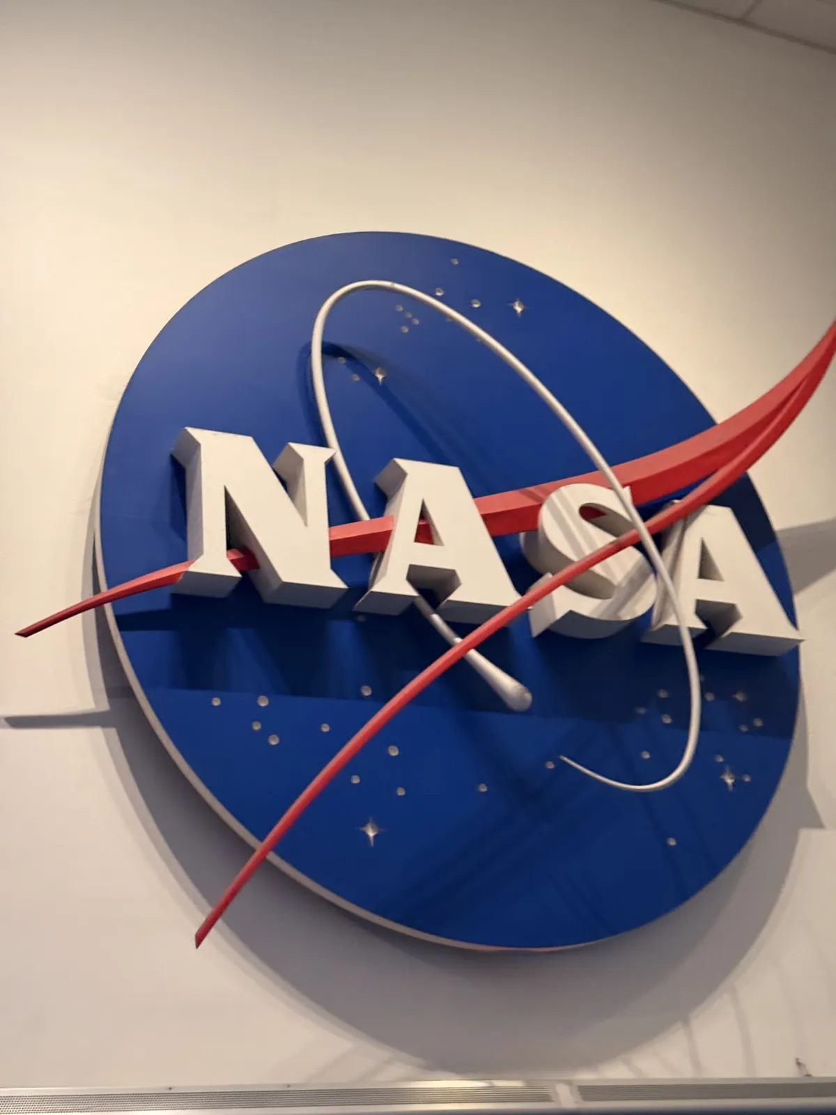 O logo da NASA, azul com a faixa vermelha, numa parede branca do Space Center Houston